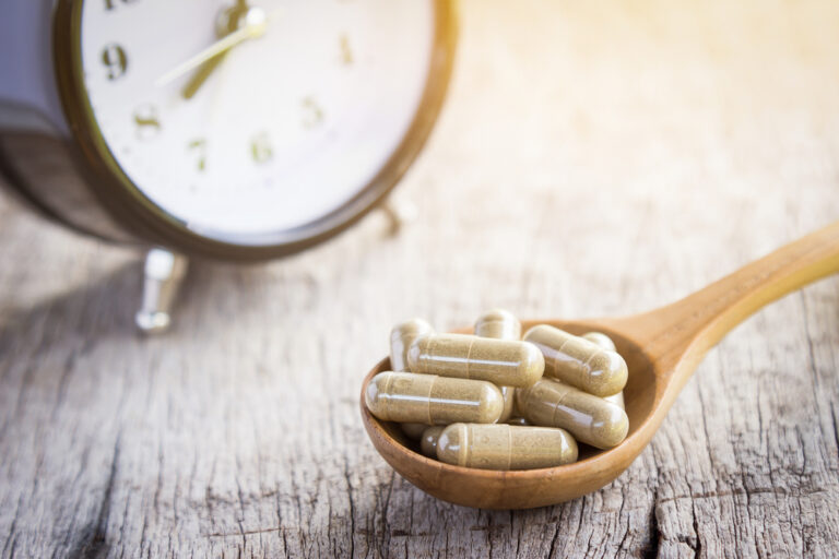 ashwagandha capsules next to alarm clock