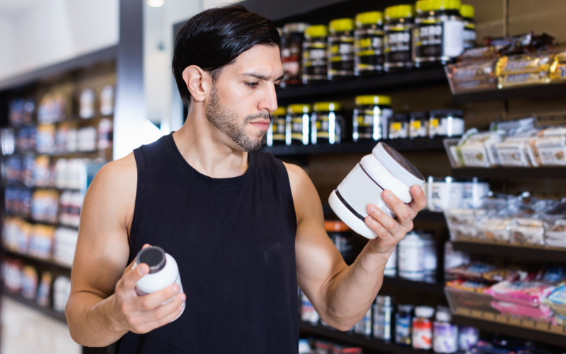 fit man looking at supplement labels fit man looking at supplement labels